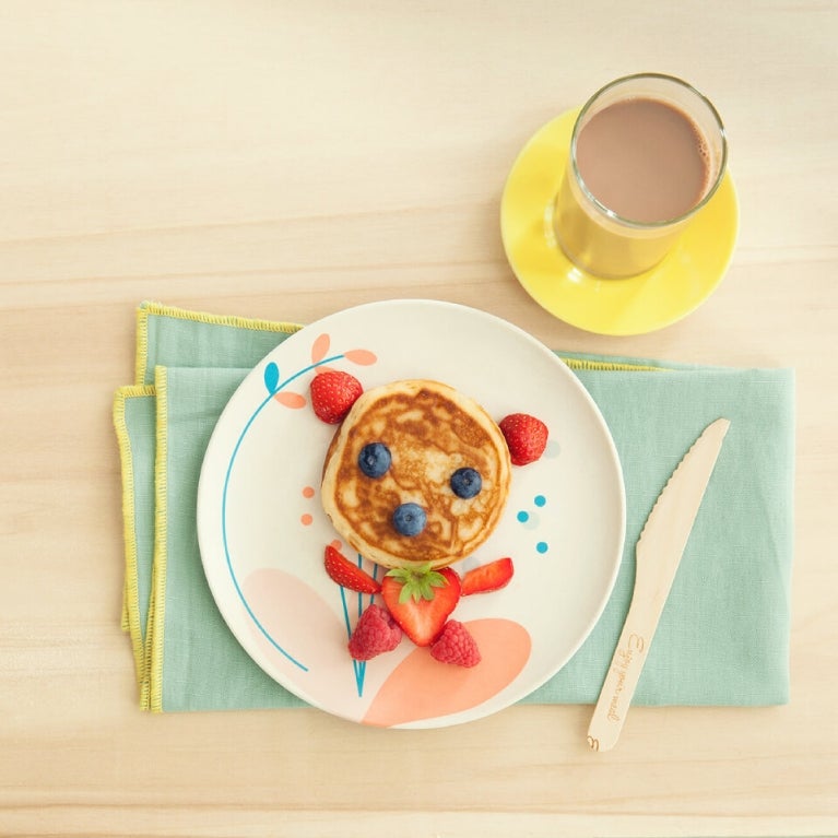 Pancakes decorated with berries and served with a glass of Nesquik Pancakes decorated with berries and served with a glass of Nesquik